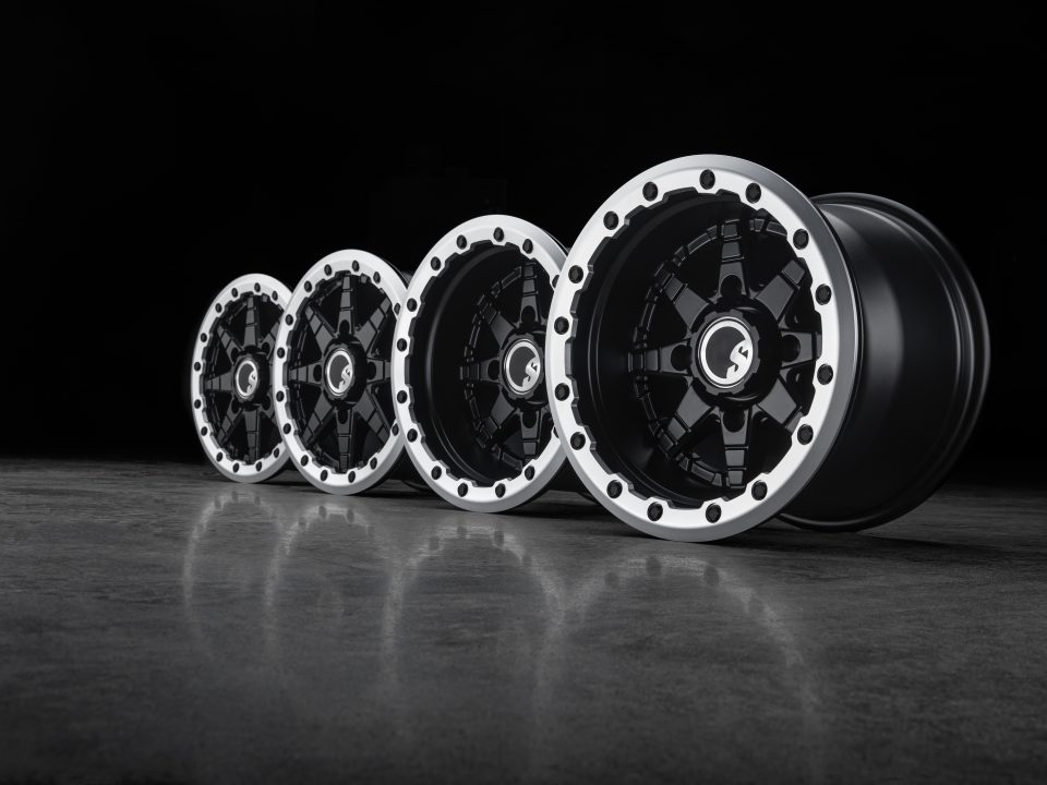 Four beadlock UTV wheels, stylishly lined up on a dark background.