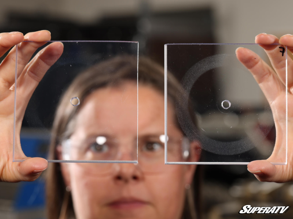 Natalie Green inspecting two pieces of polycarbonate after testing