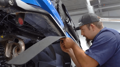 Braden starts on the rear fender flare on the Can-Am Commander. We see him reuse an OEM push pin to hold the flare in place.