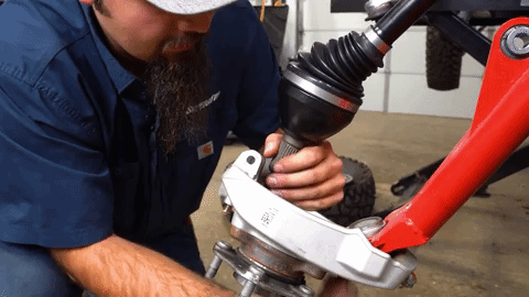 Braden slides the new Rhino 2.0 axle into the steering knuckle.