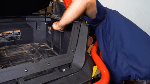 Braden takes a really awkward position to tighten the bolts under the body of the machine.