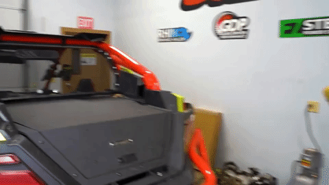 The SuperATV logo glitches and flashes in a stylized way over the fully installed trunk bed enclosure on the Polaris RZR Pro XP.
