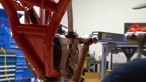 Braden uses two hammers to free the tie rod by beating on the steering knuckle.