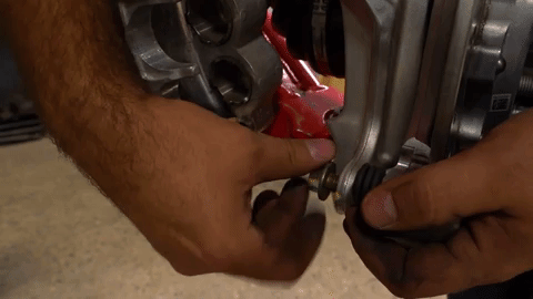 Using two fingers, Braden tightens a bolt on the caliper.