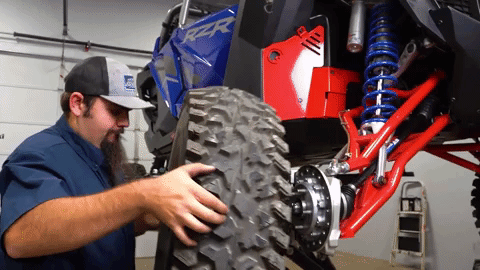 Braden maneuvers a giant tire into place to reinstall it onto the Pro R.