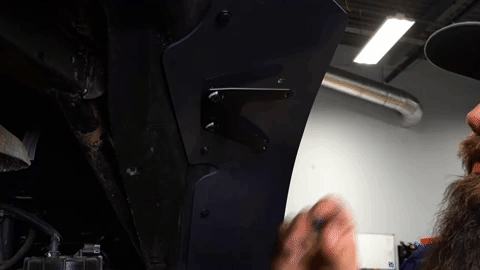 Braden pushes SuperATV-branded bolts through the top of the fender flare into the bracket.