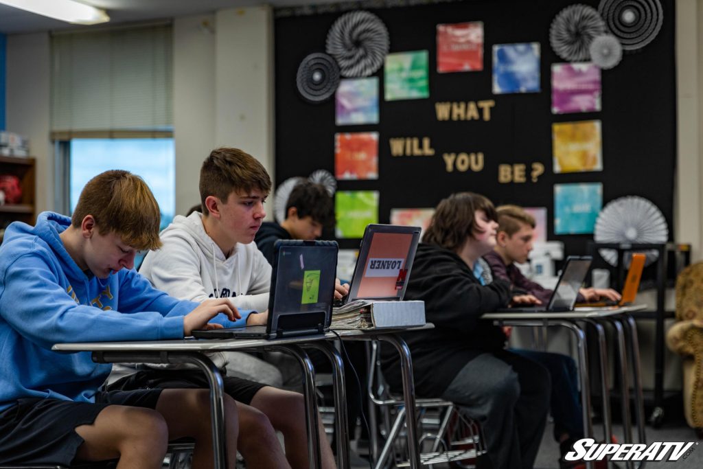 A classroom full of students working at computers