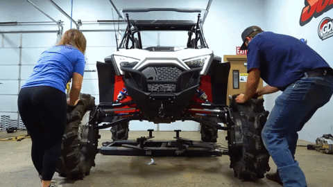 Braden and Kristen roll the RZR back and forth across the shop floor to settle the suspension.