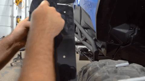A hand counts the holes drilled into the fender flare.