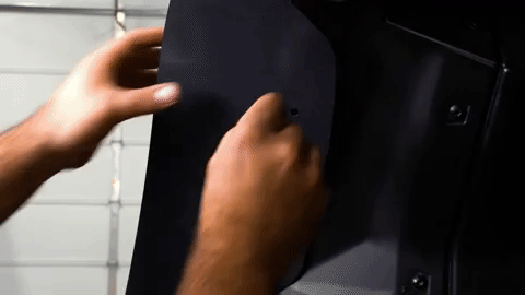 Braden inserts a push pin into the underside of the fender.