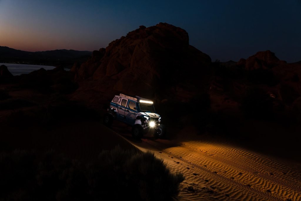 A Polaris Xpedition with multiple light bars installed lighting up a desert trail.