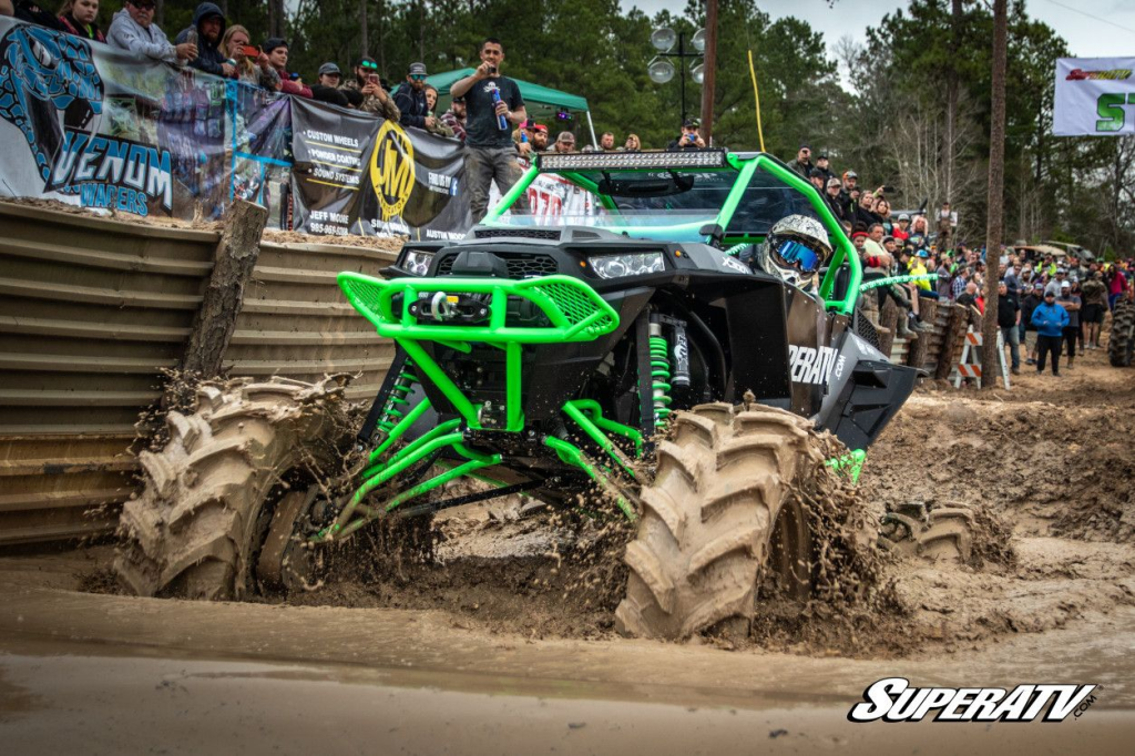 A giant SuperATV custom build running massive GDP Portals at a mud rally.