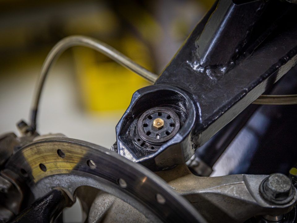 A SuperATV ball joint with adjustable cap and grease fitting installed in Can-Am Maverick X3 A-arms.
