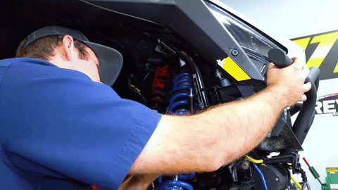 Braden removes hardware from SuperATV's aftermarket bumper that's been previously installed on this Pro XP.