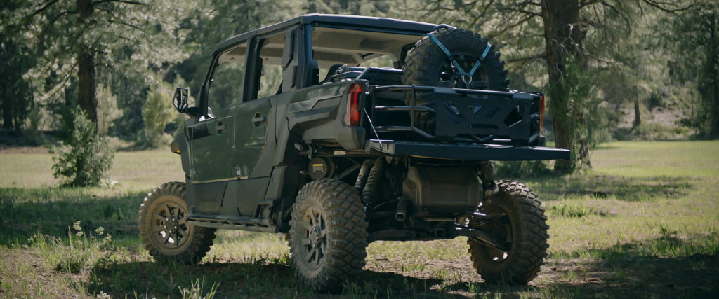 A green Polaris Xpedition with its bed down. The rear of the vehicle is facing the camera.