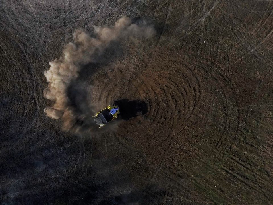 A Yamaha YXZ doing donuts in a dirt field