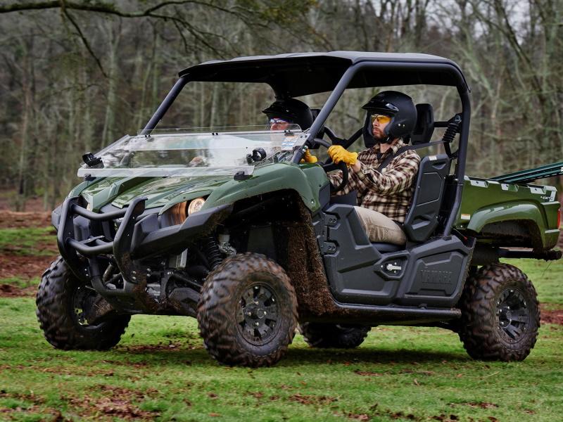 A Yamaha Viking takes on soggy turf. The bed is loaded with supplies and the tires are coated in mud.