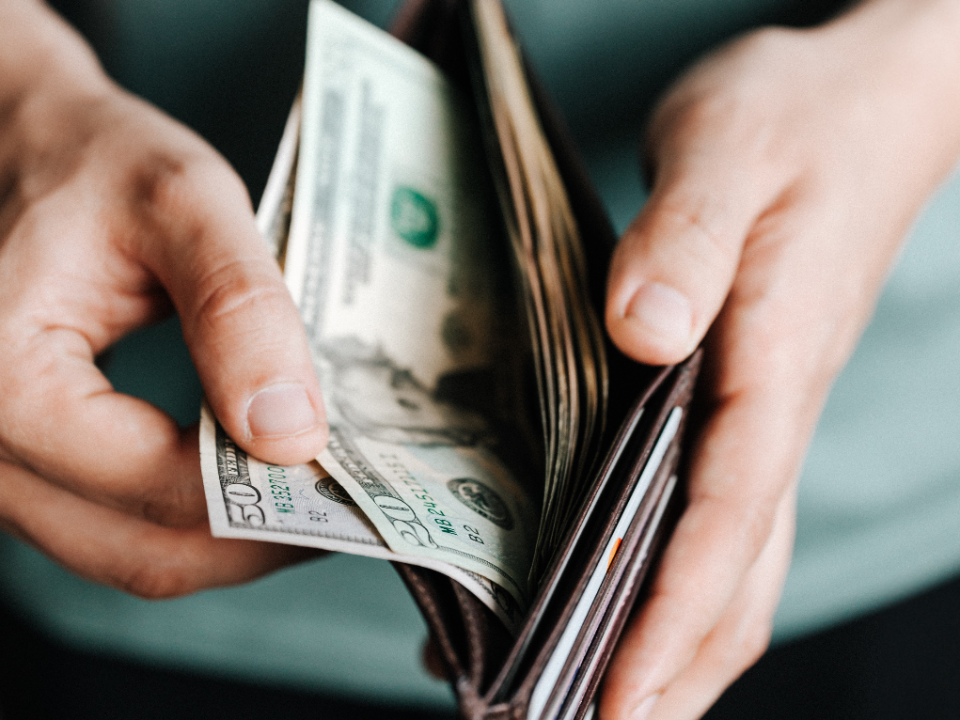 A person pulling cash from a wallet