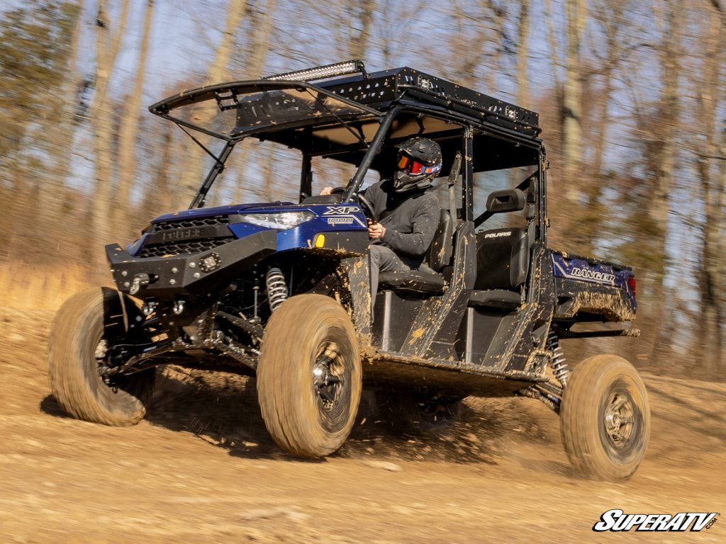 A Polaris Ranger speeding down a dirt trail.