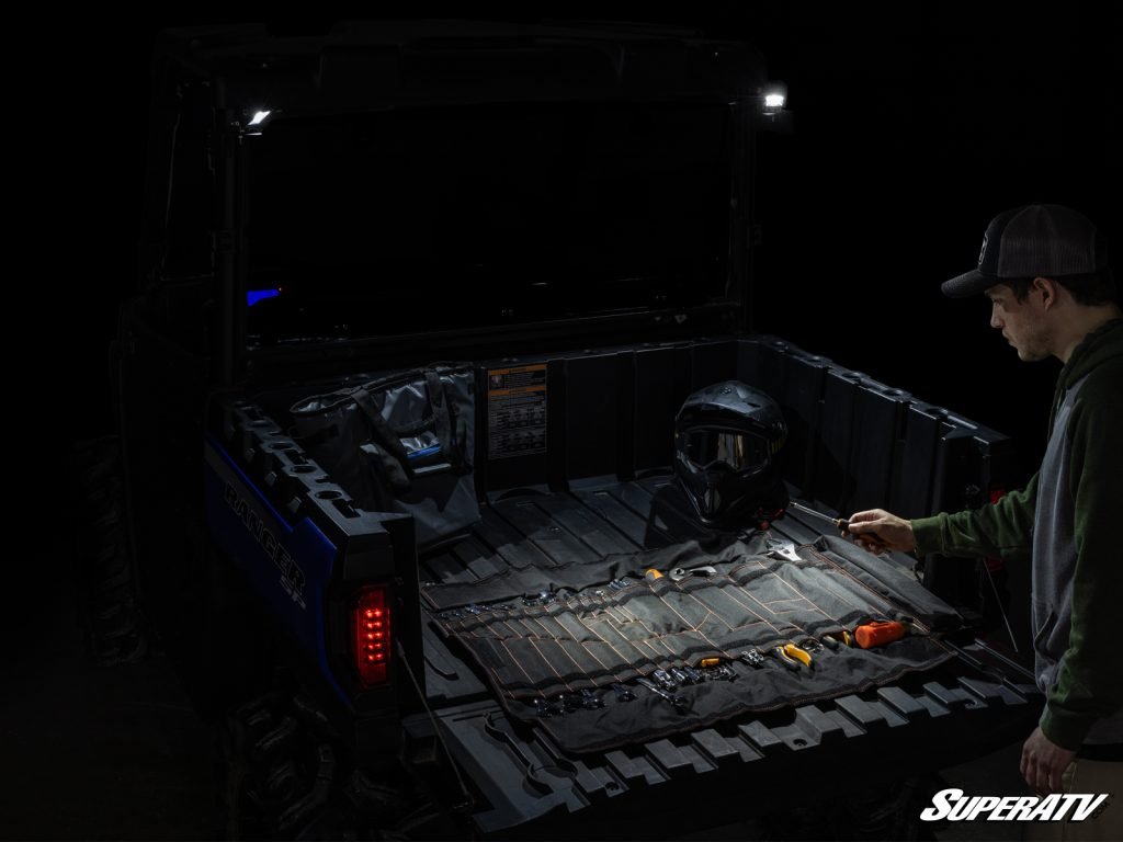 A Polaris Ranger bed lit with cube lights in the dark.