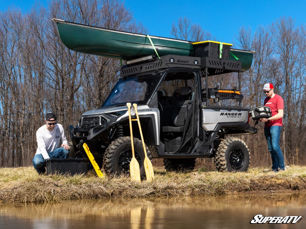 A Polaris Ranger loaded up with gear including a canoe and paddles.