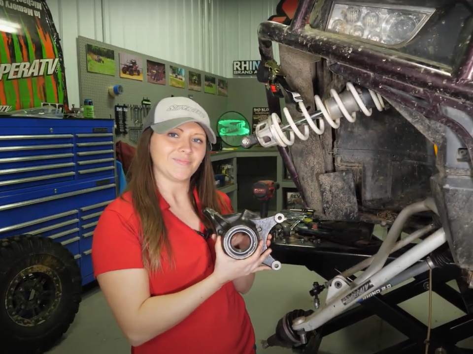 Kristen holding a spindle with a RZR wheel bearing installed.
