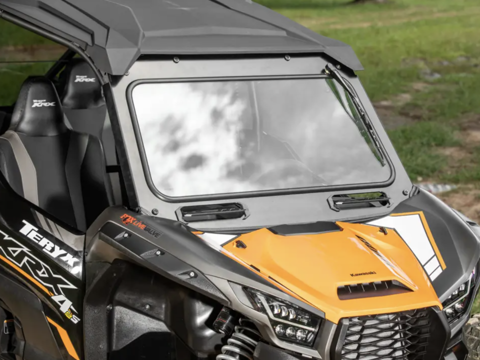 A SuperATV glass windshield installed on a yellow Kawasaki Teryx KRX 1000