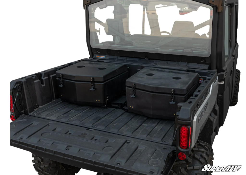 Two black coolers mounted side by side in the bed of a Can-Am Defender.