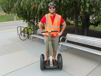 A man in a hi-vis vest using a Segway Personal Transporter