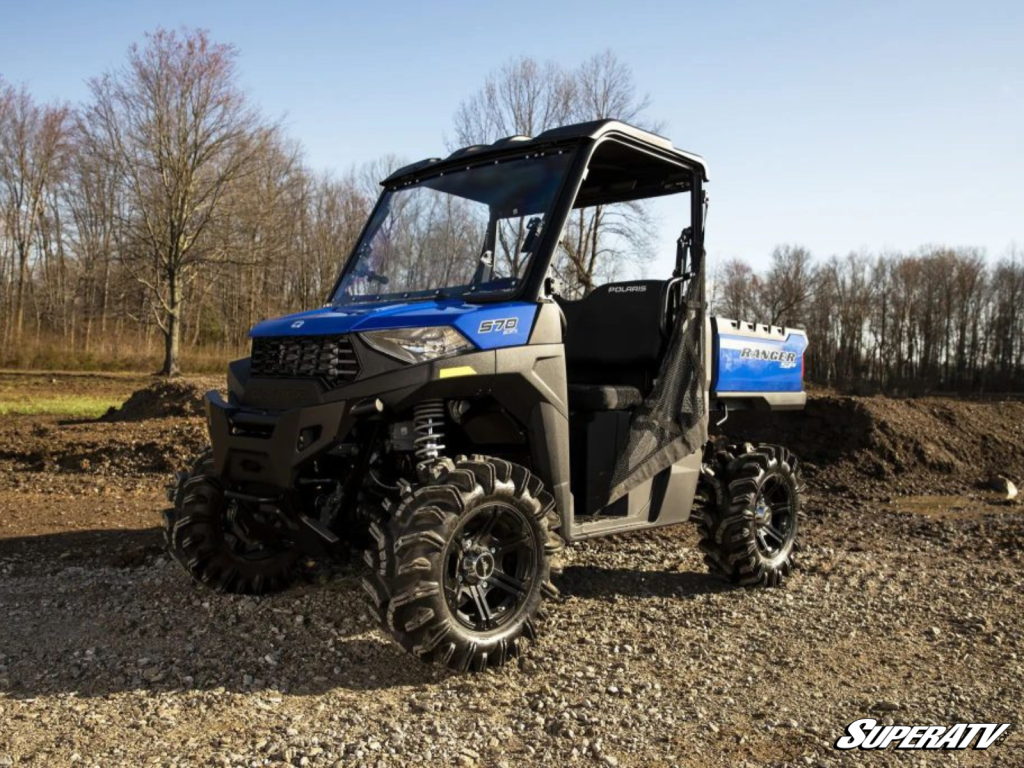 A blue Polaris Ranger parked on a rough gravel path.