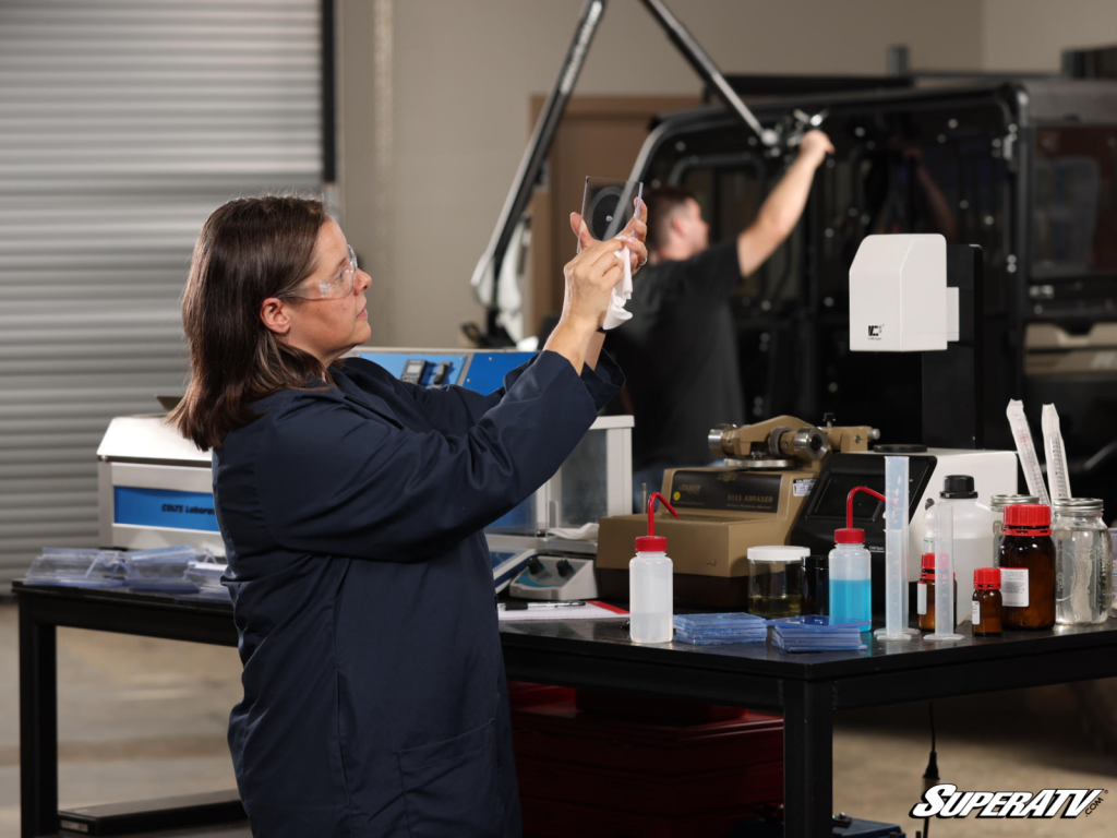 Natalie Green inspecting a piece of polycarbonate after testing