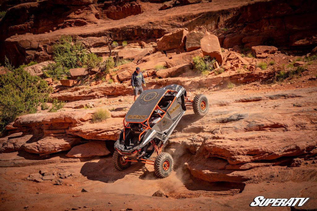 A RZR with GDP Portals crawling up a rock shelf in Moab Utah