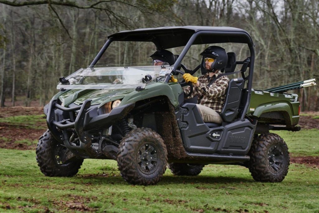 A yamaha viking EPS being used for work in a grassy setting.