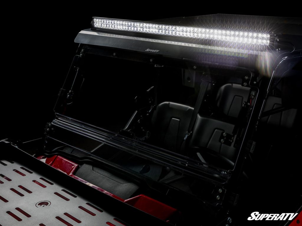 A bright light bar is installed on a UTV's roof.