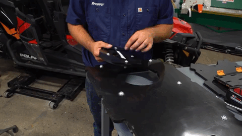 Aligning a cutout with the hole in the seat converter, the man turns it counter-clockwise to tighten it in place.