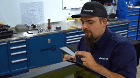 Braden wiggles a small spacer under the roof and attaches it with an Allen-headed bolt.