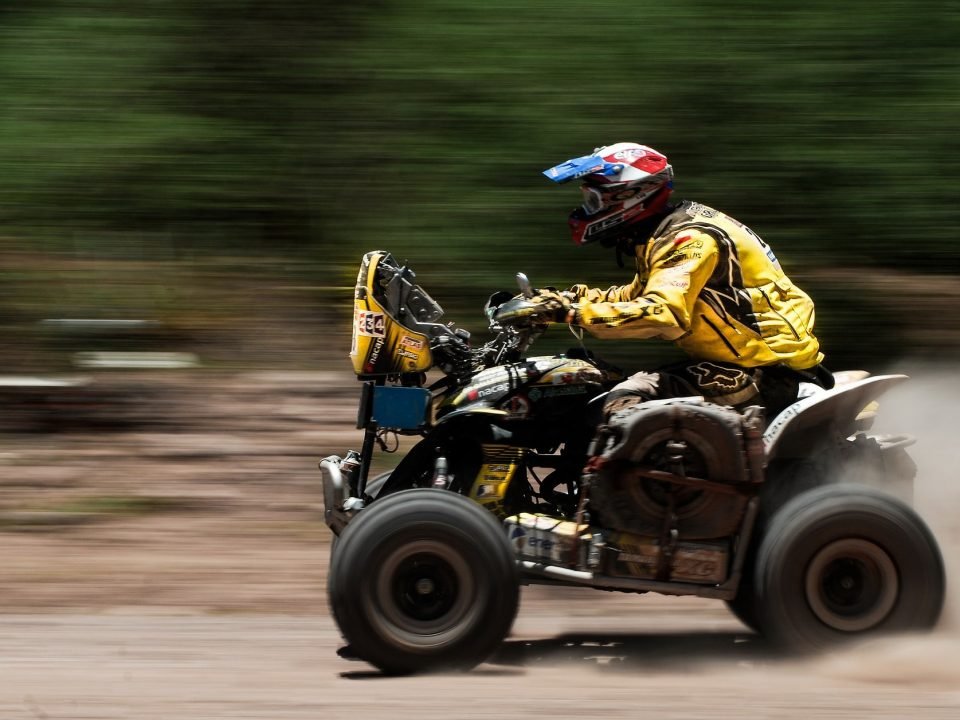 An ATV with a rider pushing it to its max speed.