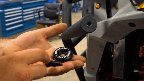 A pair of hands take a round plastic cap and places it over the end of a black tube that is the same width as the cap.