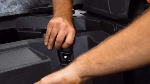 Brandon uses a drill to loosely tighten the hardware to hold it in place.