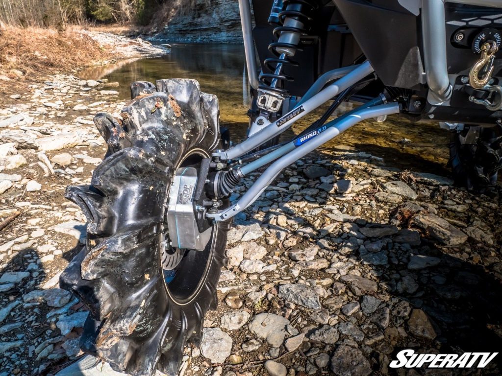A close up of a huge, lifted tire with SuperATV portals, A-arms, and Rhino 2.0 axles.