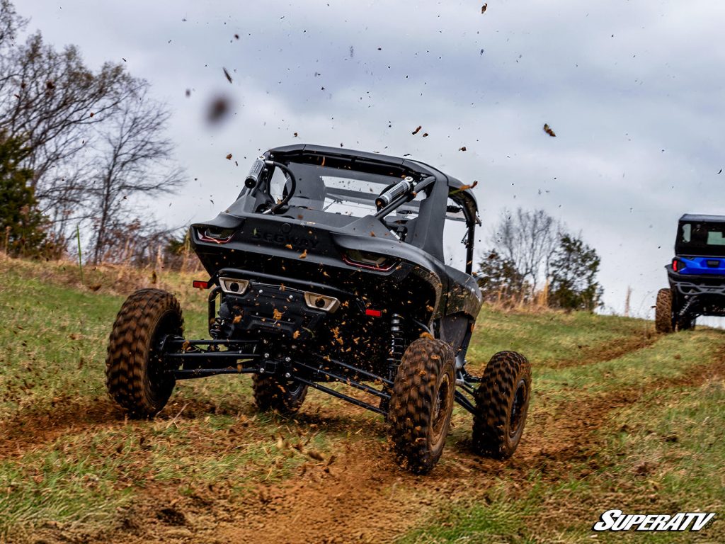 A Segway UTV kicking up mud and grass on a trail.