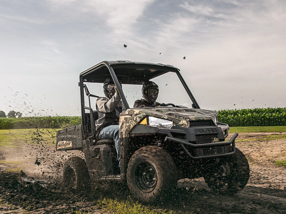 A Polaris Ranger EV Electric UTV riding through a muddy field