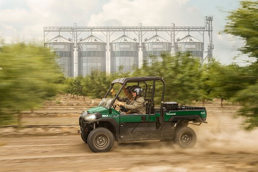 A Kawasaki Mule Pro FX moving fast on a farm