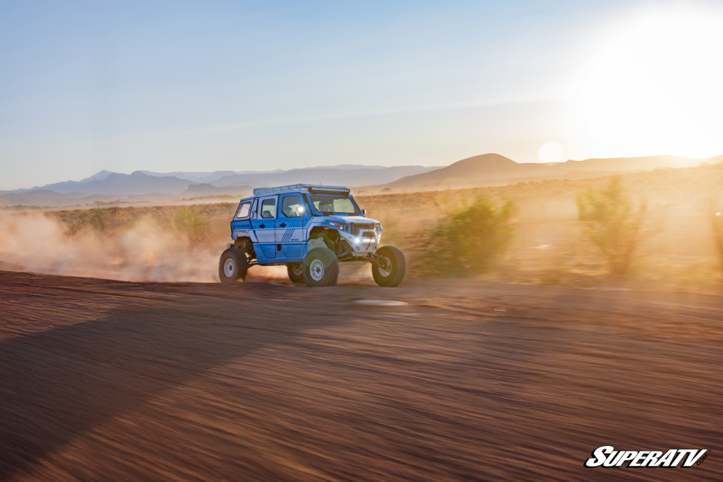 A custom wrapped Polaris Xpedition riding down a desert trail