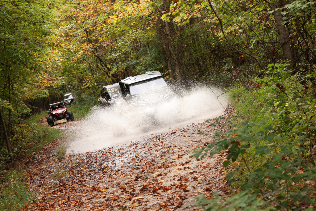 UTVs going through a deep puddle on a trail at leatherwood offroad park