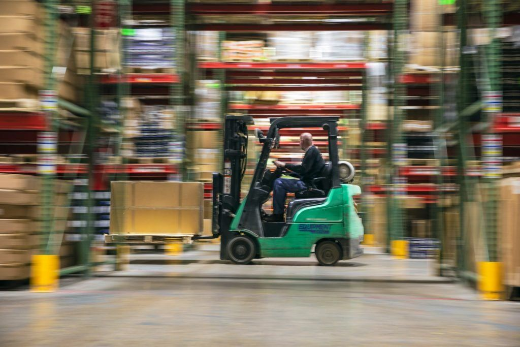 A forklift carrying UTV parts in SuperATV's warehouse.
