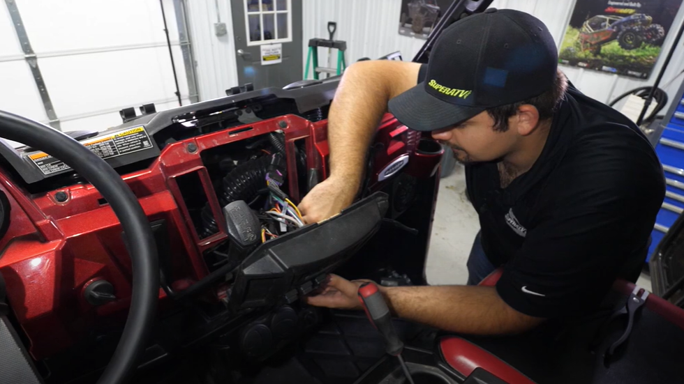 Braden punching the rocker switch through the pre-drilled holes in the dash.