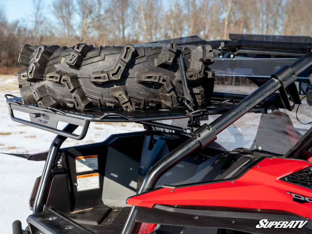 A Polaris RZR with a SuperATV Cargo Rack Alpha. It's got a big ole spare tire tied down.