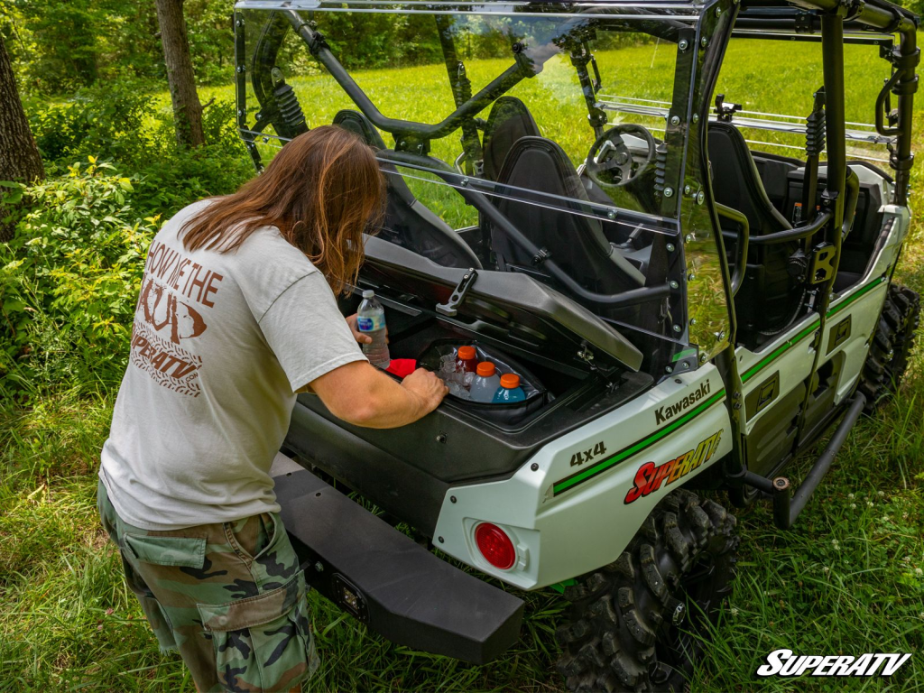 A man with long hair reaches inside a SuperATV in-bed cooler to grab a bottle of water.