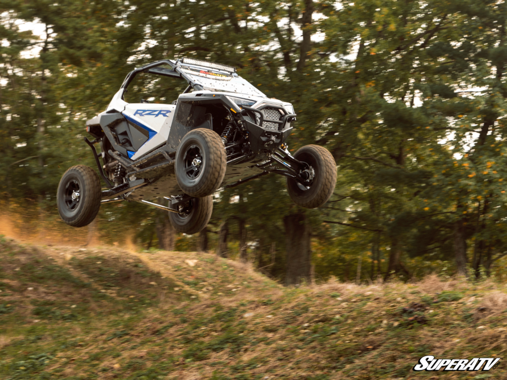 A Polaris RZR flying over a small hill, catching big air.